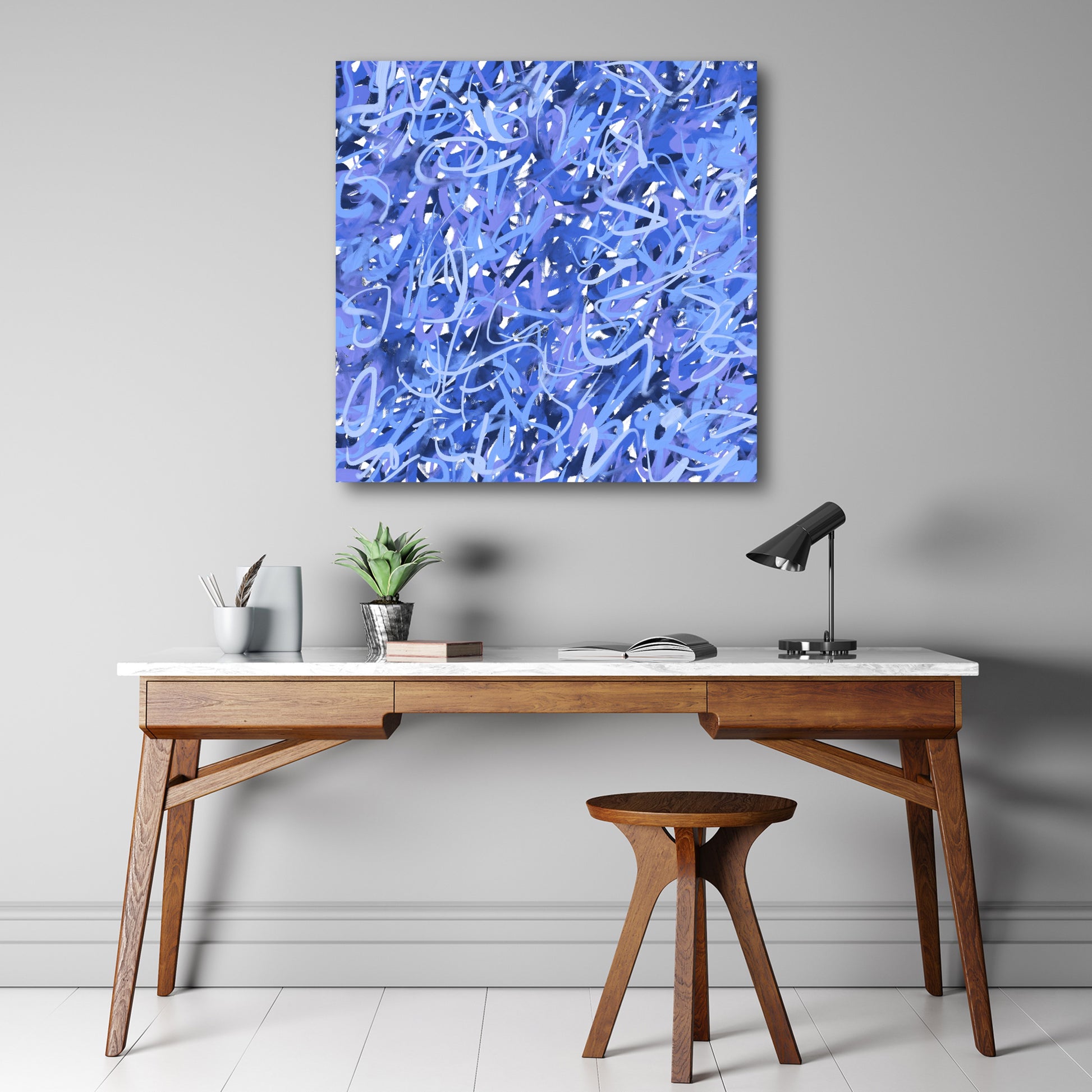 'A Touch Of Frost' hanging above a modern wooden desk with matching wooden stool. 